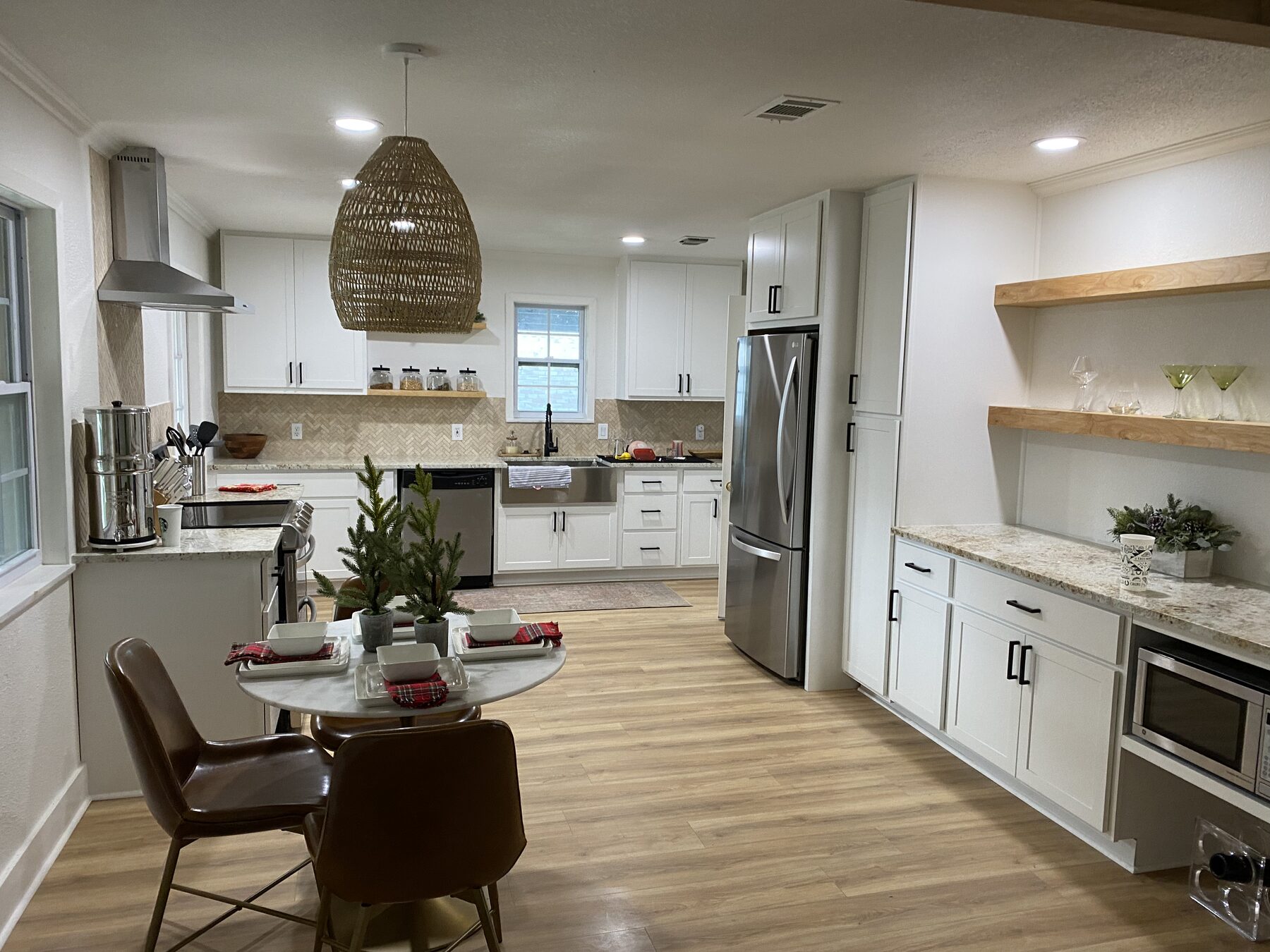 Completed open-concept kitchen with farmhouse sink, herringbone tile backsplash, and white shaker cabinetry — Lower Greenville, Dallas TX