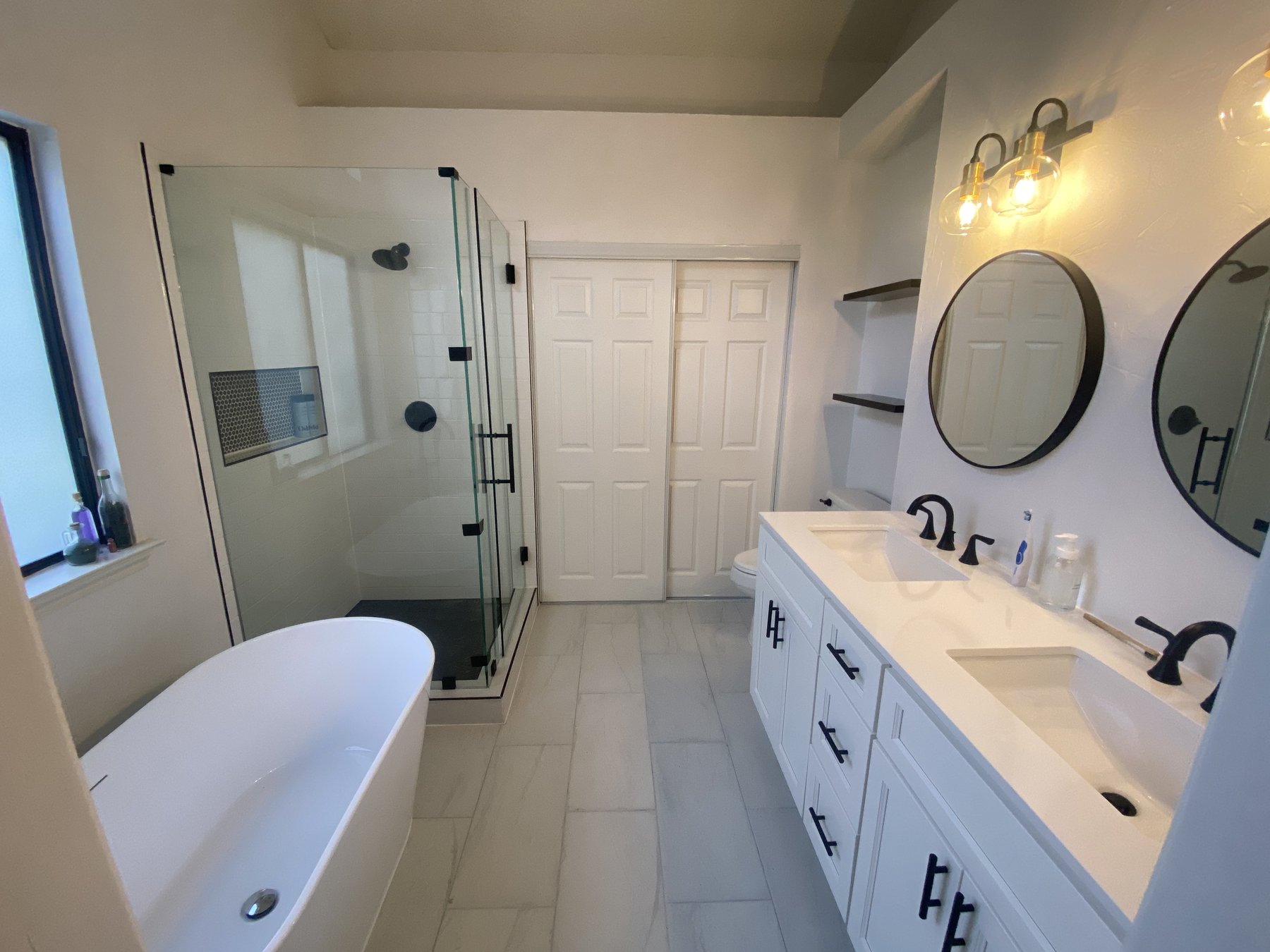 Completed primary bathroom with frameless glass shower, freestanding soaking tub, and double vanity — North Dallas, Dallas TX